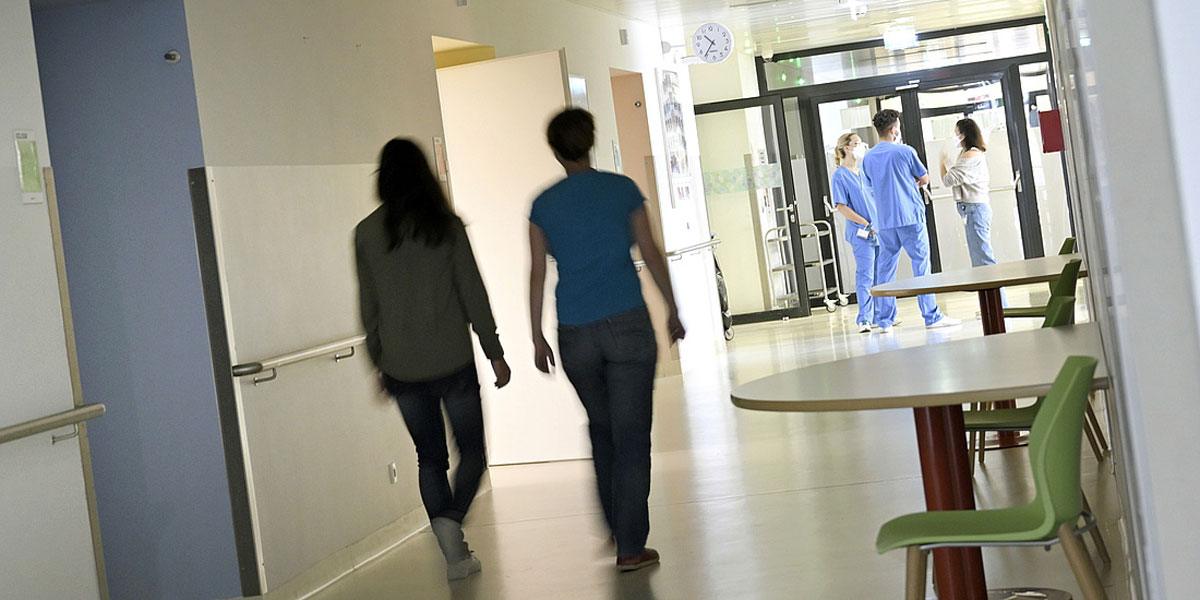 Das Foto zeigt Menschen am Gang in einem Spital
